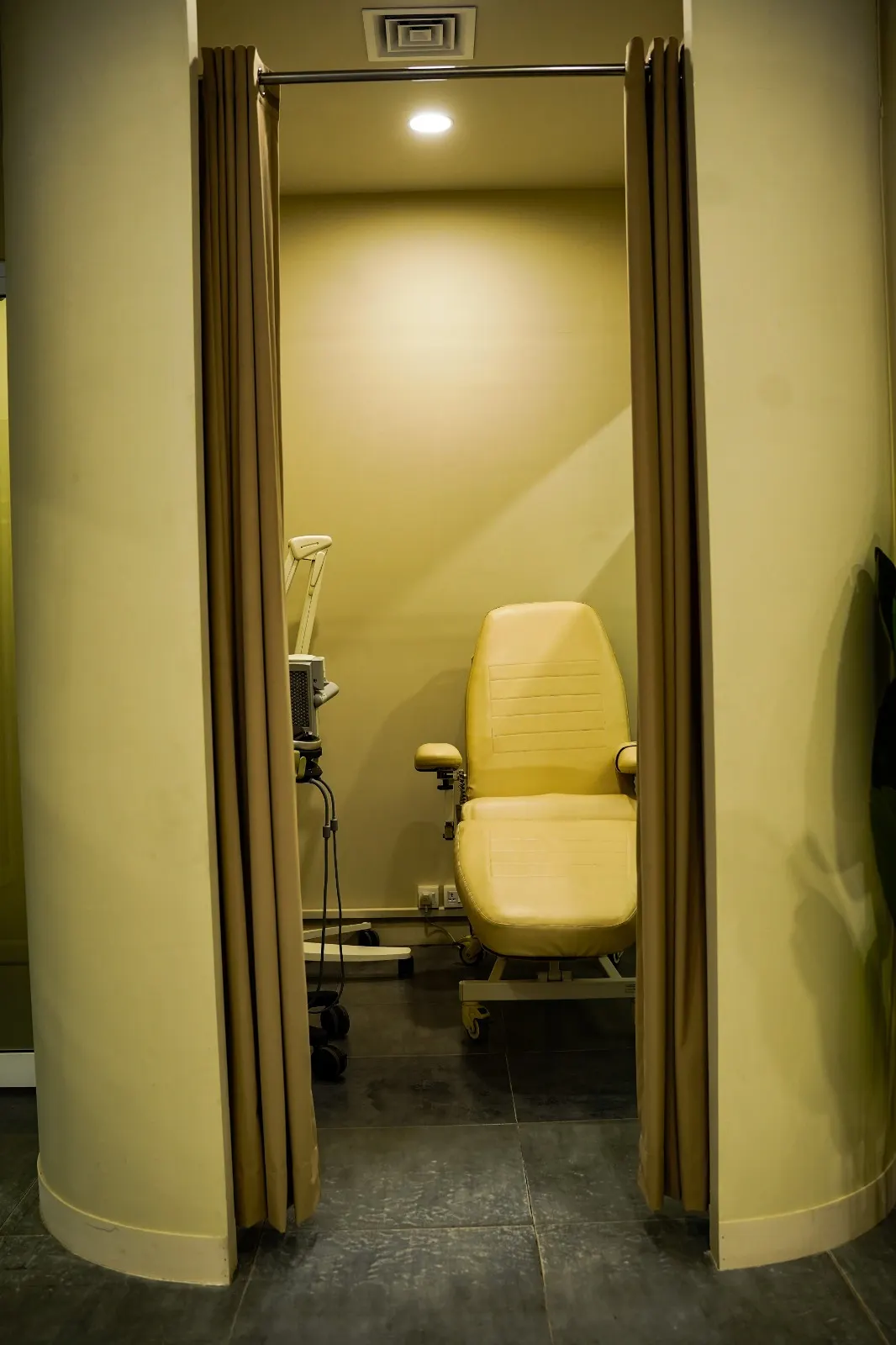 Reclining treatment chair inside a private treatment room seen through open doors